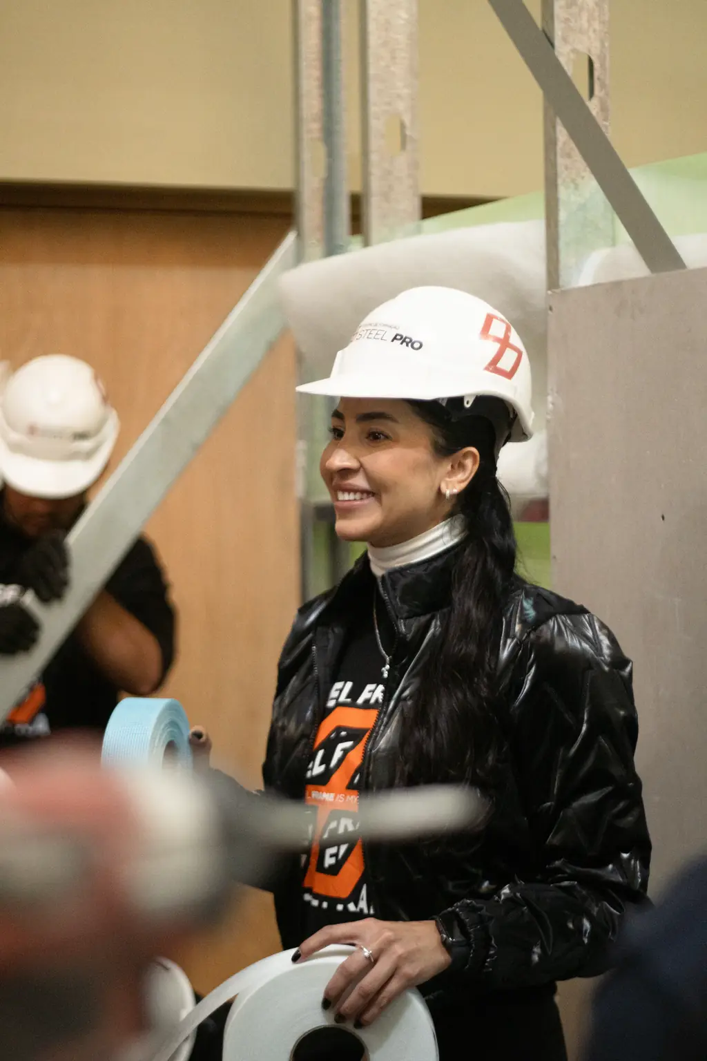Aluna sorrindo, de capacete e EPI, durante a prática